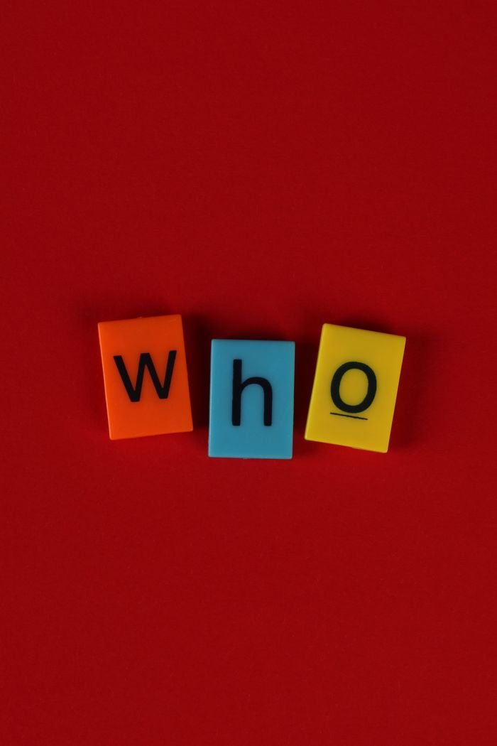 Colorful alphabet blocks spelling 'who' against a vibrant red backdrop, perfect for educational and playful themes.
